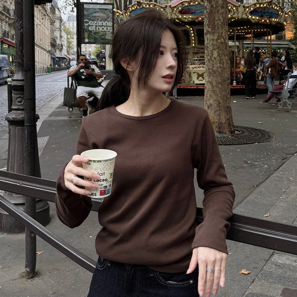 Slowand 棕色圓領長袖上衣內搭深色外套，配深色牛仔褲的咖啡店穿搭。